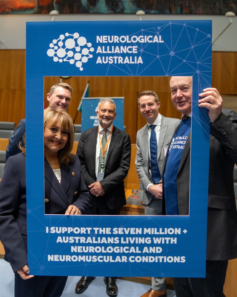 Alliance supporters at Parliament House holding a frame that reads: I support the seven million plus Australians living with neurological and neuromuscular conditions